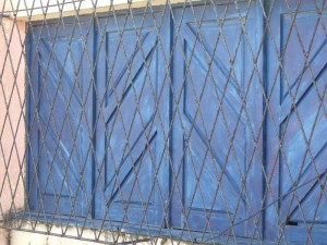 Bild eines Fensters, das aus Gitter und Fensterläden besteht.