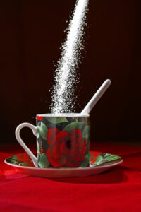 Zucker rieselt in eine Tasse
